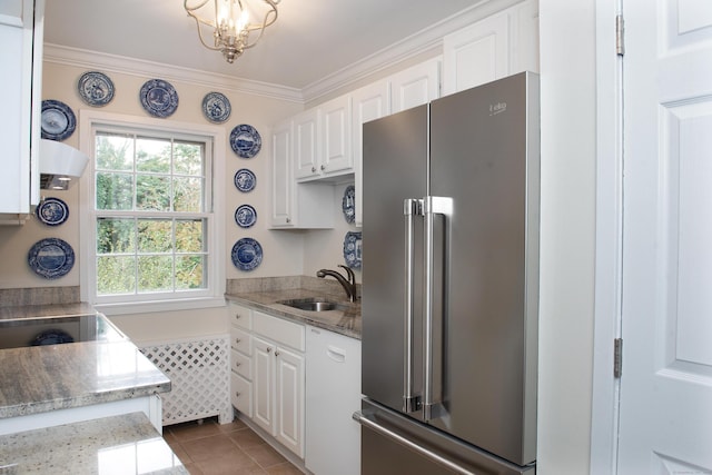kitchen featuring high end fridge, tile patterned flooring, white cabinetry, crown molding, and a sink