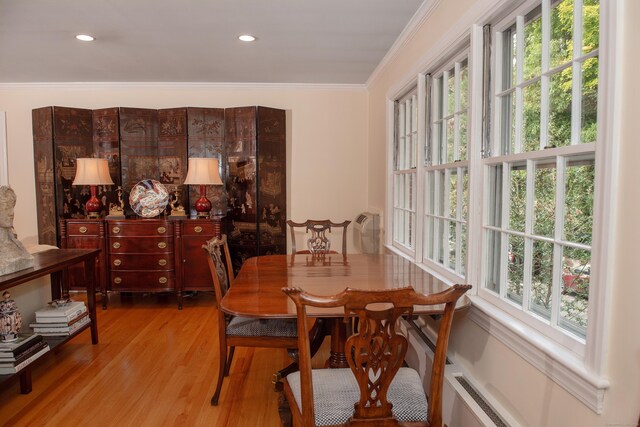 dining room with light hardwood / wood-style flooring, ornamental molding, and a healthy amount of sunlight