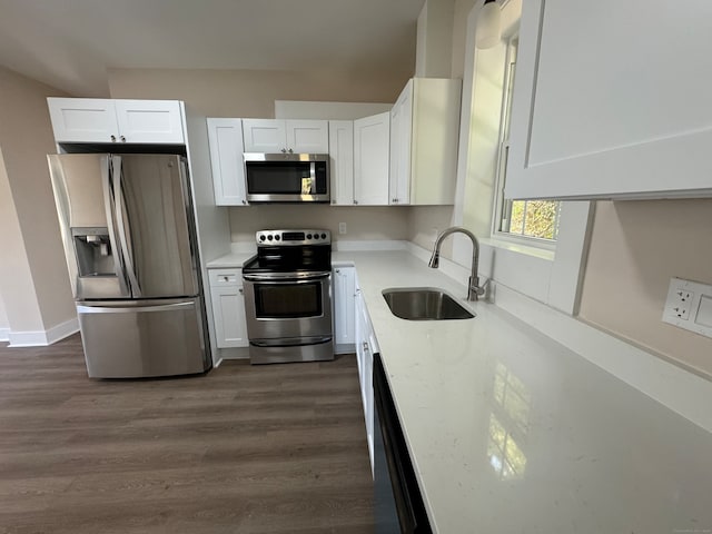 kitchen with white cabinets, appliances with stainless steel finishes, sink, and dark hardwood / wood-style flooring