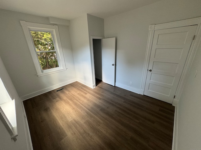 unfurnished bedroom with dark wood-type flooring