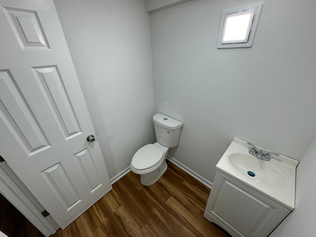 bathroom with wood-type flooring, vanity, and toilet