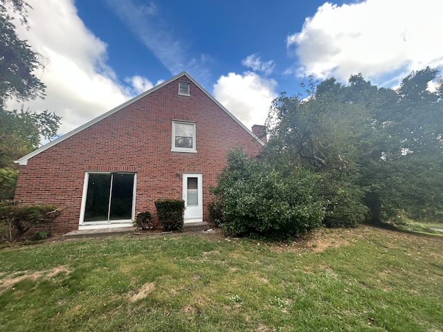 rear view of house featuring a lawn