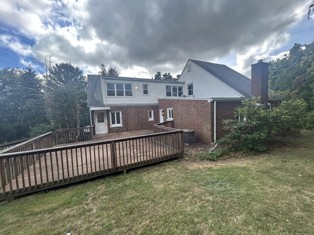 1920 Hartford Tpke, North Haven, CT 06473 - rear view of house featuring brick siding, a deck, a chimney, and a lawn