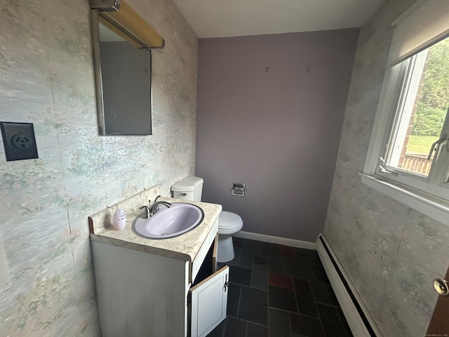 bathroom featuring a baseboard heating unit, vanity, and toilet