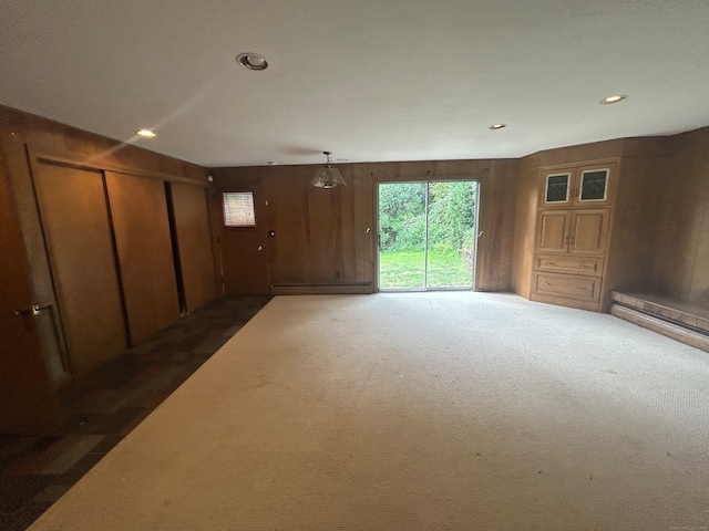 carpeted empty room with wood walls