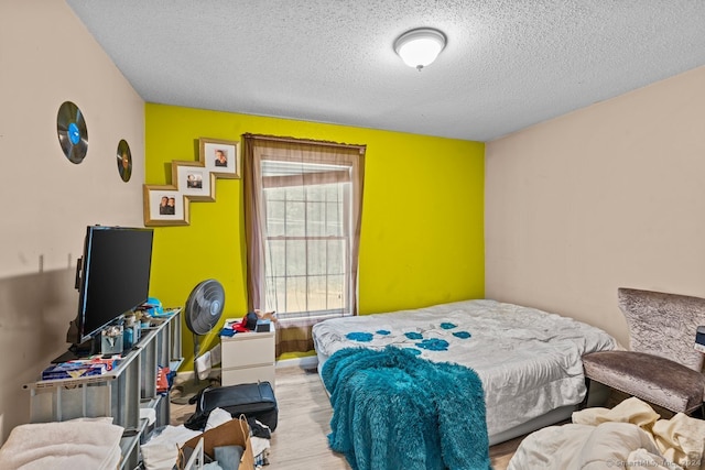 bedroom featuring light hardwood / wood-style floors and a textured ceiling