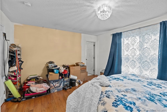 bedroom featuring wood-type flooring and a textured ceiling