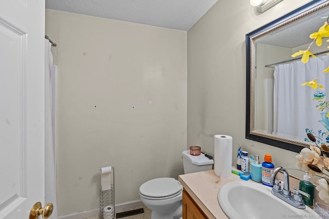 bathroom featuring vanity, toilet, and a textured ceiling