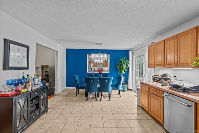 kitchen featuring dishwasher, hanging light fixtures, an inviting chandelier, a textured ceiling, and light tile patterned floors