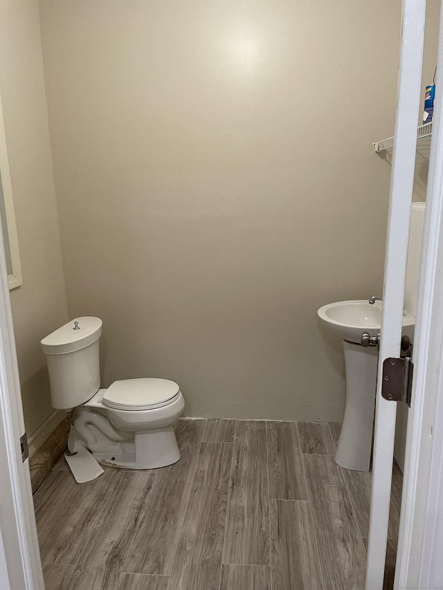 bathroom with hardwood / wood-style flooring and toilet