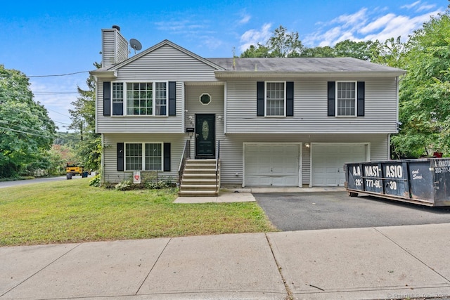 bi-level home featuring a front lawn and a garage