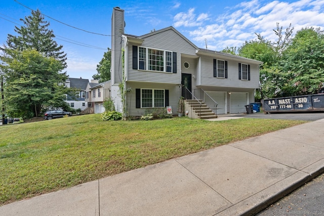 bi-level home with a front yard and a garage