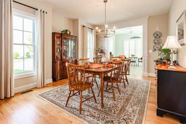 dining space featuring light hardwood / wood-style flooring, plenty of natural light, and ceiling fan with notable chandelier