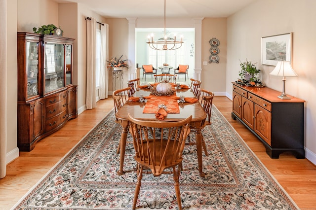 dining room with light hardwood / wood-style flooring, a notable chandelier, and plenty of natural light