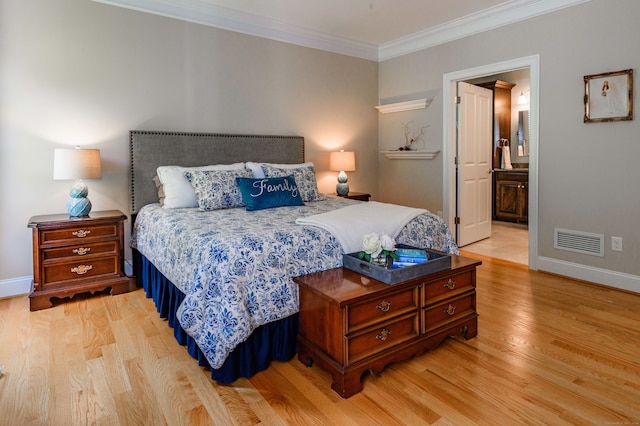 bedroom with light hardwood / wood-style floors, ornamental molding, and ensuite bath