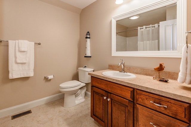 bathroom with vanity, tile patterned flooring, toilet, and walk in shower