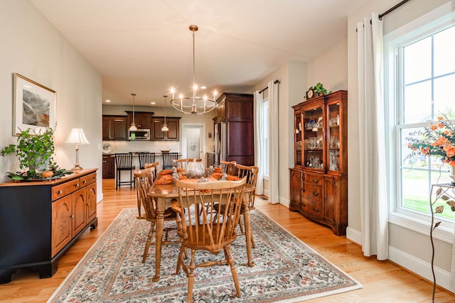 dining space featuring a chandelier, plenty of natural light, and light wood-type flooring