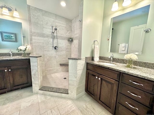 bathroom with vanity and a tile shower