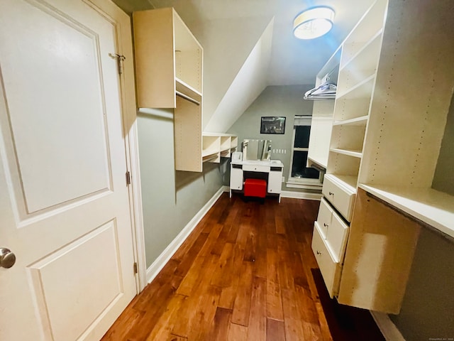 walk in closet featuring dark hardwood / wood-style floors and vaulted ceiling