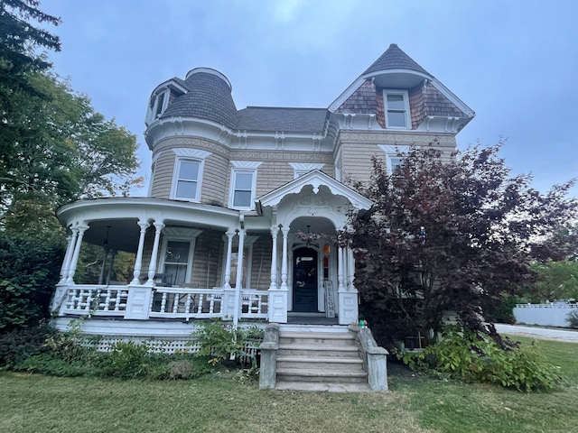 victorian home with a front yard and a porch