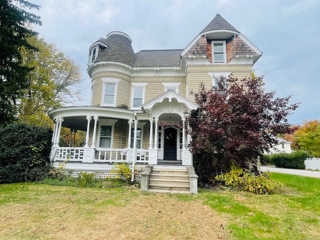 victorian house featuring a porch and a front yard