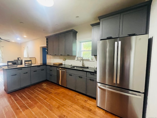 kitchen with wood-type flooring, gray cabinetry, sink, and stainless steel appliances