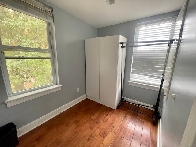 unfurnished bedroom with hardwood / wood-style floors and multiple windows