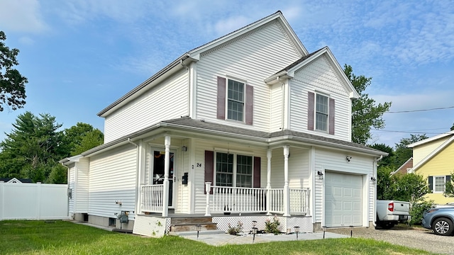 view of front facade featuring a front yard, a garage, and a porch