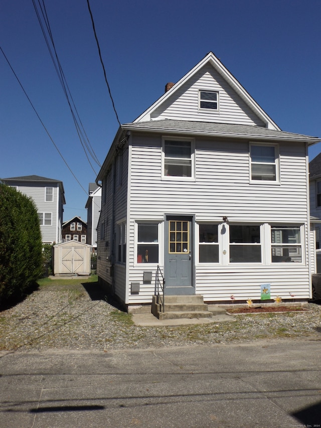 view of front of property featuring a shed