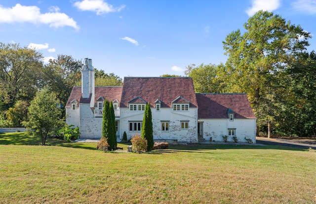 rear view of house featuring a yard