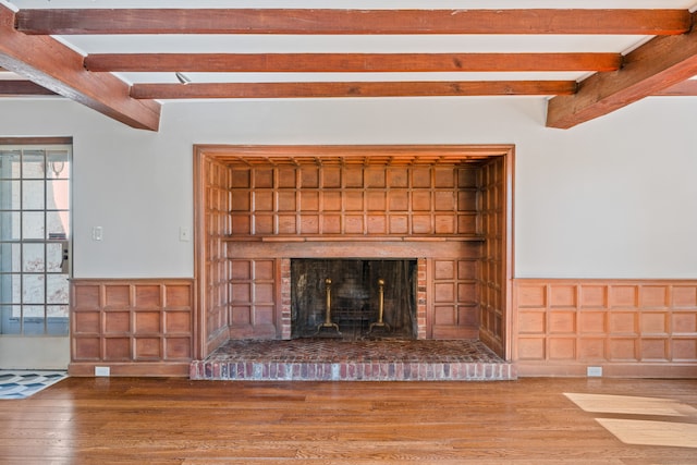 room details with beamed ceiling, a fireplace, and hardwood / wood-style floors