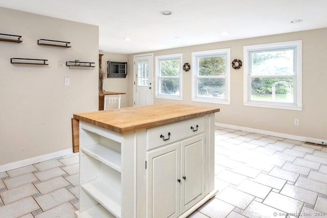 kitchen featuring a center island, white cabinets, and butcher block countertops