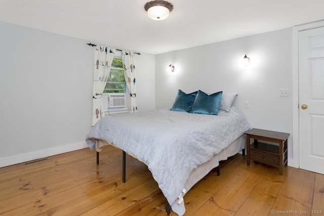 bedroom with hardwood / wood-style flooring and cooling unit