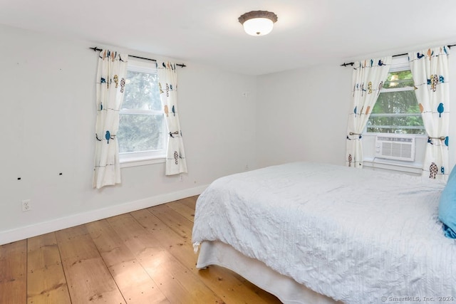 bedroom with hardwood / wood-style flooring and cooling unit