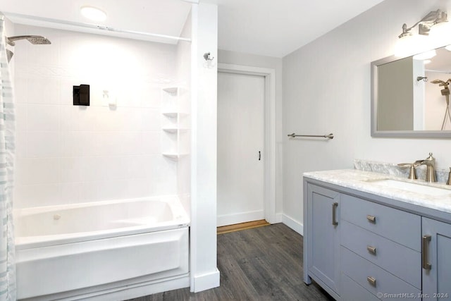 bathroom featuring hardwood / wood-style flooring, washtub / shower combination, and vanity