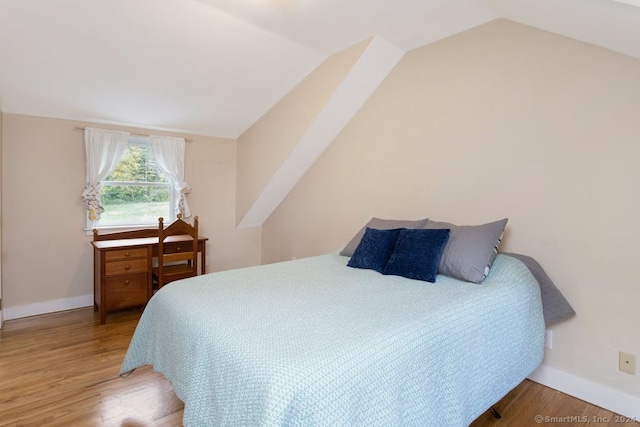 bedroom with hardwood / wood-style flooring and vaulted ceiling