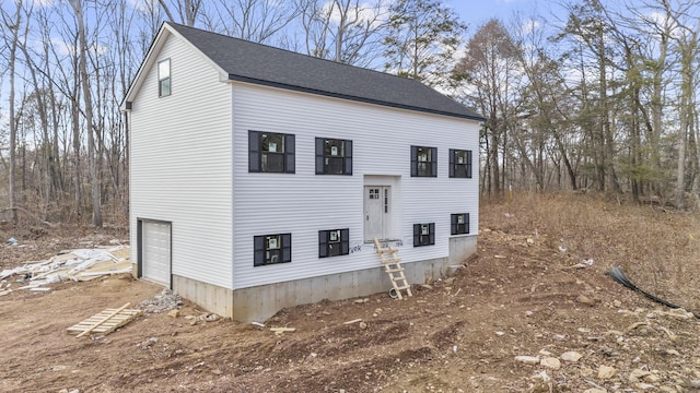 view of side of home with roof with shingles and an attached garage