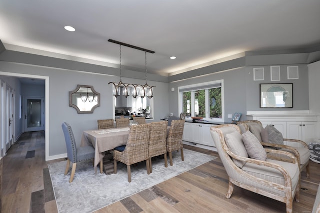 dining room with dark hardwood / wood-style flooring and an inviting chandelier