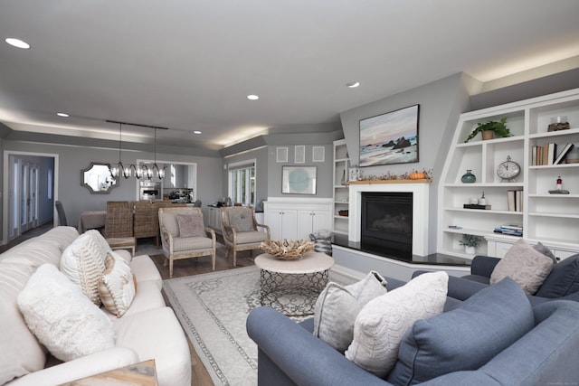 372 Maple Ave, Old Saybrook, CT 06475 - living area with wood finished floors, a chandelier, recessed lighting, a fireplace with raised hearth, and built in features