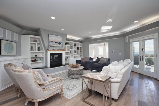372 Maple Ave, Old Saybrook, CT 06475 - living area featuring french doors, wood finished floors, a glass covered fireplace, and recessed lighting