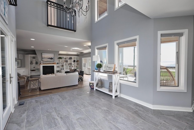 372 Maple Ave, Old Saybrook, CT 06475 - living room featuring a fireplace, a chandelier, and a high ceiling