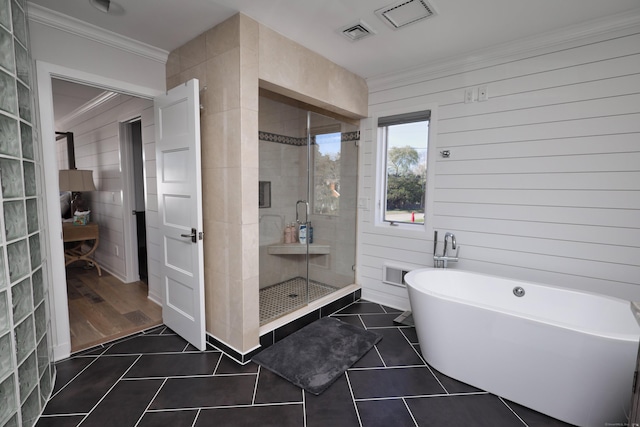 372 Maple Ave, Old Saybrook, CT 06475 - full bath featuring ornamental molding, a shower stall, a soaking tub, tile patterned floors, and tile walls