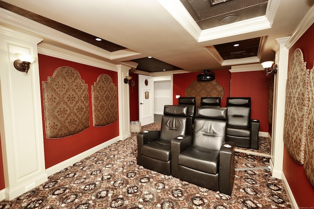 carpeted home theater room with decorative columns, ornamental molding, and a tray ceiling