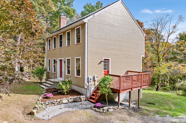 view of property exterior with a yard and a wooden deck