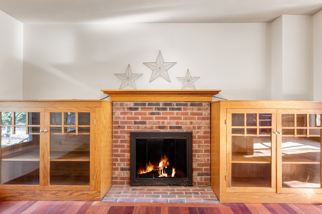 unfurnished living room with a brick fireplace and hardwood / wood-style floors