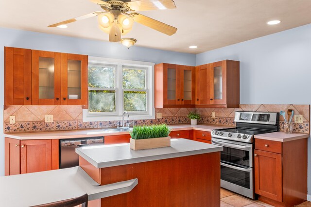 kitchen with ceiling fan, decorative backsplash, stainless steel appliances, sink, and light tile patterned flooring