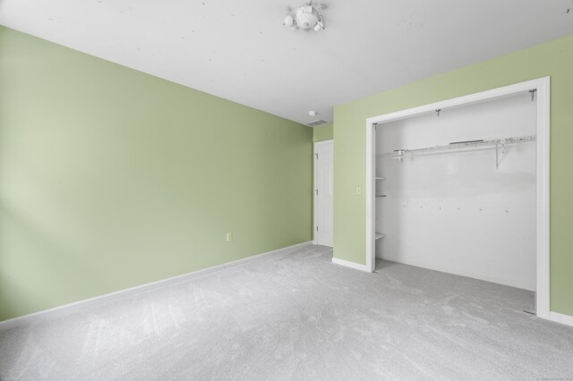 unfurnished bedroom featuring carpet floors and a closet