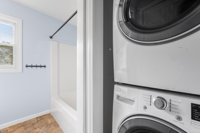 washroom featuring stacked washer / drying machine