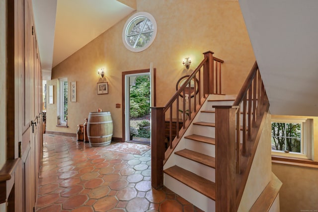 stairs featuring high vaulted ceiling