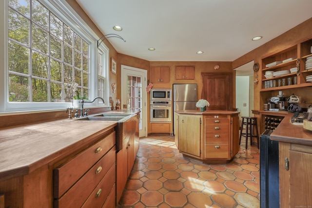 kitchen with light tile patterned floors, stainless steel appliances, and sink